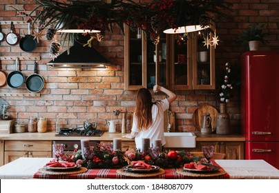 Teen Girl In The Kitchen With Table Set Decorated For Christmas Dinner