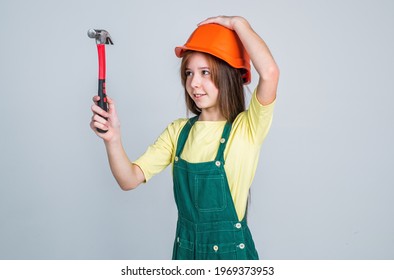 Teen Girl Laborer In Protective Helmet And Uniform On Grey Background Use Hammer, Worker