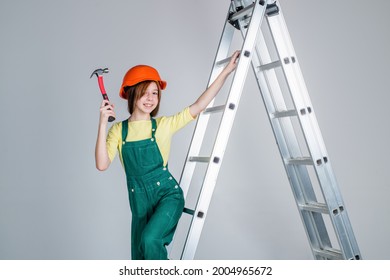 Teen Girl Laborer In Protective Helmet And Uniform On Ladder With Hammer, Constraction