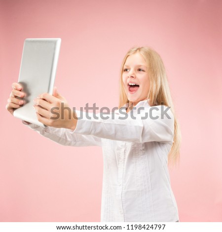 Teen girl with laptop. Love to computer concept. Attractive female half-length front portrait, trendy pink studio backgroud. Human emotions, facial expression concept.