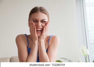 Teen Girl Laughing Holding Hands On Blush Rosy Cheeks, Happy Young Woman Feeling Shy Embarrassed Making Videocall, Hysterical Laughter Of Unexpected Surprise, Strong Emotional Reaction, Head Shot