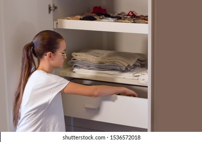 Teen Girl Order The Linens In The Closet. Concept Of Order, Cleanliness In Wardrobe And Home, Collaboration Of The Teenagers To Keep The Home Environments Tidy.