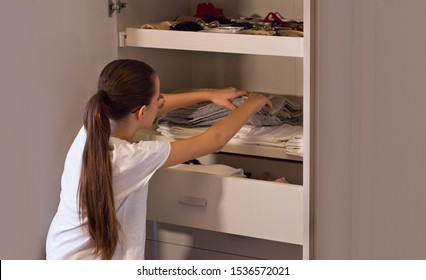 Teen Girl Order The Linens In The Closet. Concept Of Order, Cleanliness In Wardrobe And Home, Collaboration Of The Teenagers To Keep The Home Environments Tidy.