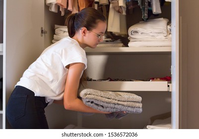 Teen Girl Order The Linens In The Closet. Concept Of Order, Cleanliness In Wardrobe And Home, Collaboration Of The Teenagers To Keep The Home Environments Tidy.