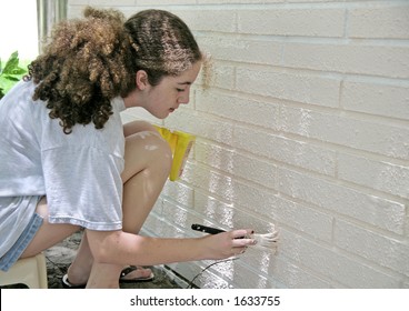 A Teen Girl Painting House Trim.  Room For Text.