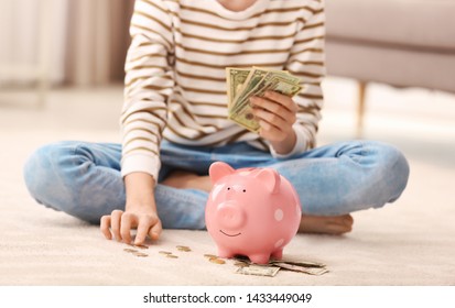 Teen Girl With Piggy Bank And Money At Home, Closeup