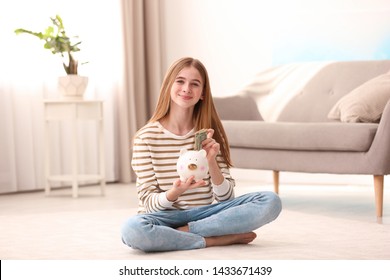 Teen Girl With Piggy Bank And Money At Home