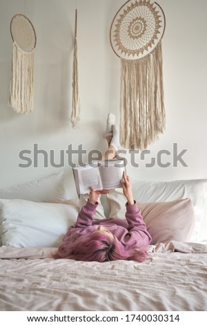 Similar – Image, Stock Photo Young adult woman lying in bed and with her cat and pile of books in her hands