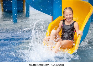 Teen Girl Playing In The Swimming Pool On Slide