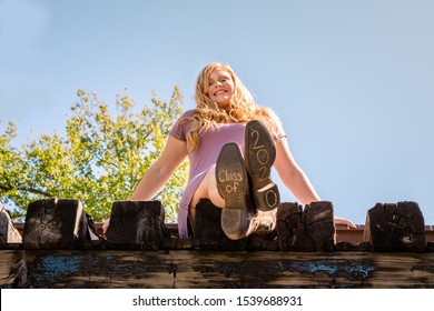 Teen Girl Poses For A High School Senior Portrait Photo Outdoors On A Bridge