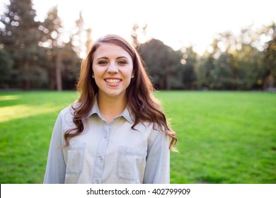 Teen Girl Poses For A High School Senior Portrait Photo Outdoors Near A River In Eugene Oregon.