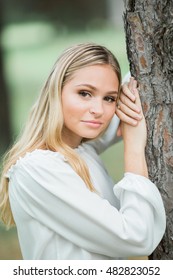 Teen Girl Poses For A High School Senior Portrait Photo Outdoors By Tree