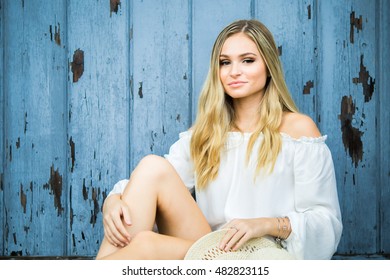 Teen Girl Poses For A High School Senior Portrait Photo Outdoors With Wooden Blue Background