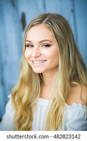 Teen Girl Poses For A High School Senior Portrait Photo Outdoors With Wooden Blue Background