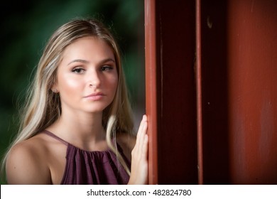 Teen Girl Poses For A High School Senior Portrait Photo Outdoors In A Purple Dress