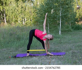 Teen girl practices yoga in Utthita Trikonasana, extended triangle pose. 