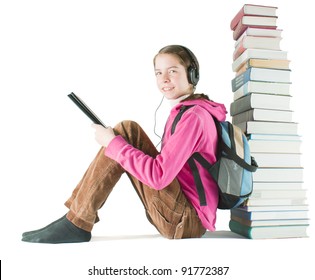 Teen girl reads ebook sitting near the stack of printed books
