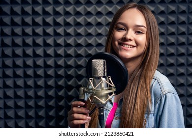 Teen Girl In Recording Studio With Mic Over Acoustic Panel Background