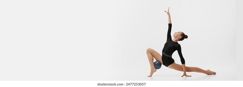 Teen girl, rhythmic gymnast performing with ball, showing skills and stay isolated on white background. Concept of sport, retro and vintage, active lifestyle, hobby. Banner - Powered by Shutterstock