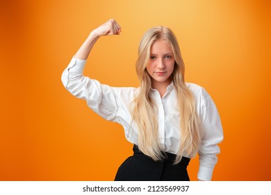 Teen Girl Showing Off Muscles Biceps Against Orange Background