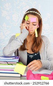 Teen Girl Sitting At Desk With Homework For School And Having A Lot To Remember