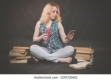 Teen Girl Sitting On The Floor Next To Books, Does Not Want To Learn, Drinking Juice And Taking A Selfie On The Smartphone