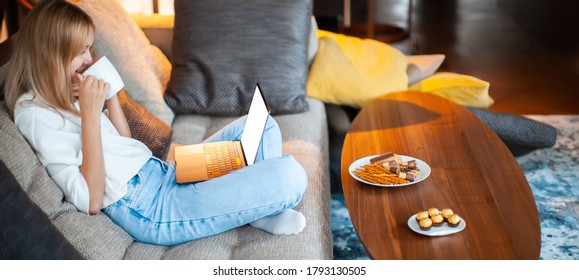 Teen Girl Sitting On Sofa In Lotus Position With Blank Screen Laptop Watching TV Series. Close Up Photo For Ad Or Blog