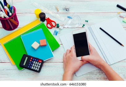 Teen Girl With Smartphone Doing Homework.  Distracted Talking On A Phone