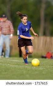 Teen Girl Soccer Player Runs After Yellow Soccer Ball