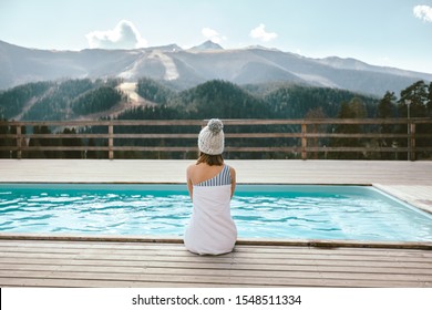 Teen Girl Spending Winter Or Spring Vacation In Luxury Spa Resort With Swimming Pool Over Alpine Mountain Landscape