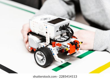Teen girl student with diy robot on stem education class.Teen scientist working on new project.Stem education Learning To Program Robot Vehicle.