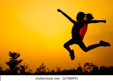 Teen Girl In Superhero Costume Jumping In The Evening On The Nature