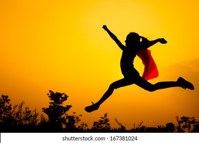 Teen Girl In Superhero Costume Jumping In The Evening On The Nature