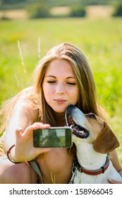 Teen Girl Taking Photo Of Herself And Her Dog With Mobile Phone Camera