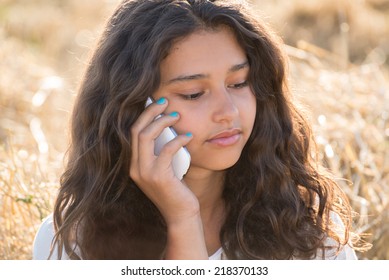 Teen Girl Talking On The Phone Outdoors