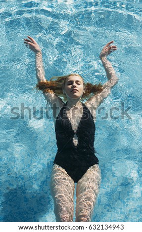 Teen girl underwater at the pool on a summer day
