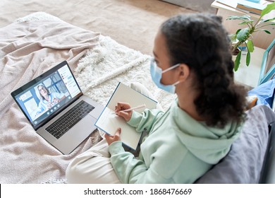 Teen Girl Wearing Face Mask Remote Studying Online With Web Teacher At Home. African Teenager Distance Learning Watching Webinar, Virtual School Class With Tutor Using Laptop Elearning During Covid.