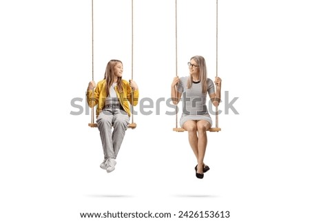 Teen girl and a young woman sitting on wooden swings isolated on white background