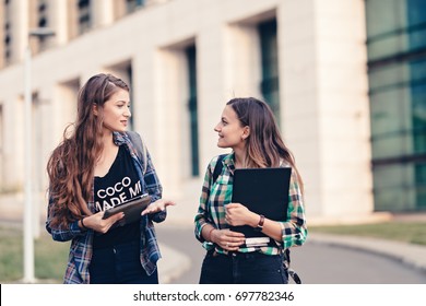 Teen Girls First Day Of School Outfit. Friends Walking On The Road. Opening The Tablet And Showing Photos. Really Funny Photos. Happy Faces, Eager To See What Is Showing. Tablet Holding Tight.