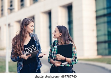 Teen Girls First Day Of School Outfit. Friends Walking On The Road. Opening The Tablet And Showing Photos. Really Funny Photos. Happy Faces, Eager To See What Is Showing. Tablet Holding Tight.