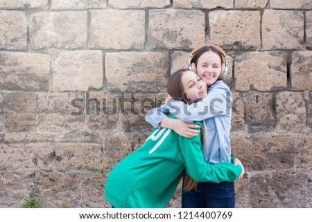 Teen girls have fun at old brick wall background