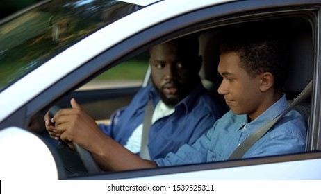 Teen Guy Feeling Upset Of Driving, Dad Angrily Looking At Son, Misunderstanding