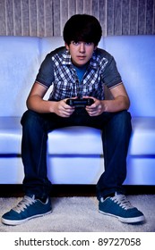 Teen With Joystick Playing Computer Game In Darkness