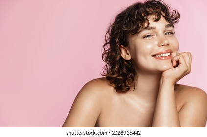 Teen Model With Curly Hair And Clean Natural Glowing Skin, White Smile, Looking Happy At Camera. Promo Of Skin Care And Spa Products For Body And Face. Pink Studio Background