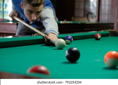 Teen Playing In American Pool Billiard On Green Table.