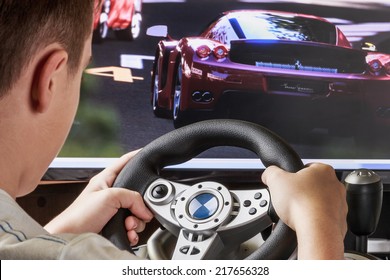 Teen Playing In The Race Behind The Wheel Of A Game Console 