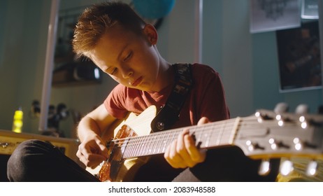 Teen Rocker Playing Guitar During Rehearsal In Bedroom