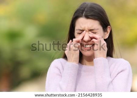 Teen scratching itchy eyes complaining outdoors in a park Stok fotoğraf © 