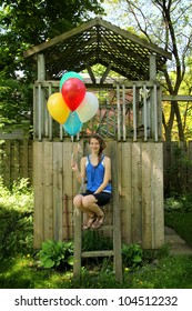 Teen Sitting On A Ladder Of A Little Wood House