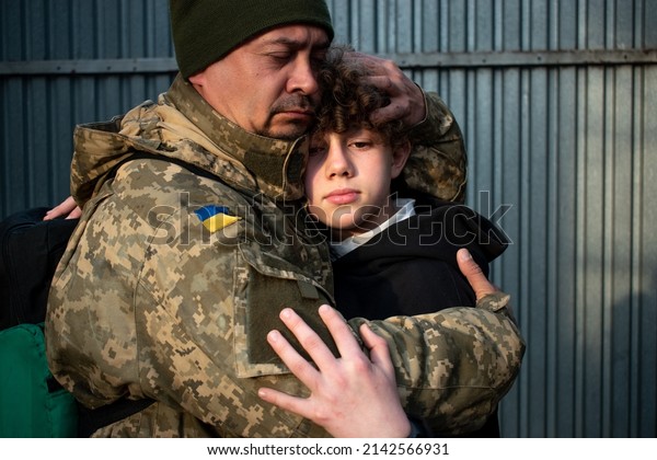 Teen son says goodbye to her military father. Son\
hugs a dad Ukrainian soldier. Ukrainian defender says goodbye to\
his family. Mobilization of Ukrainian men. War in Ukraine.\
Defenders of Ukraine